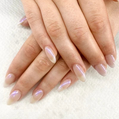 Close-up of hands with light clear nail polish on a white background