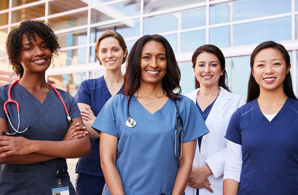 Group of nurses standing together in front of a building